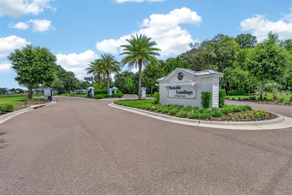 The entrance to a residential community features a sign for Seaside Landings at Flagler Beach — 142 SEASIDE POINT, FLAGLER BEACH, FL