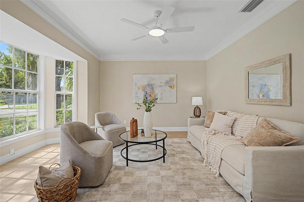 A living room features a beige sofa, two armchairs, a glass coffee table, and windows — 15602 INDIAN QUEEN DRIVE, ODESSA, FL