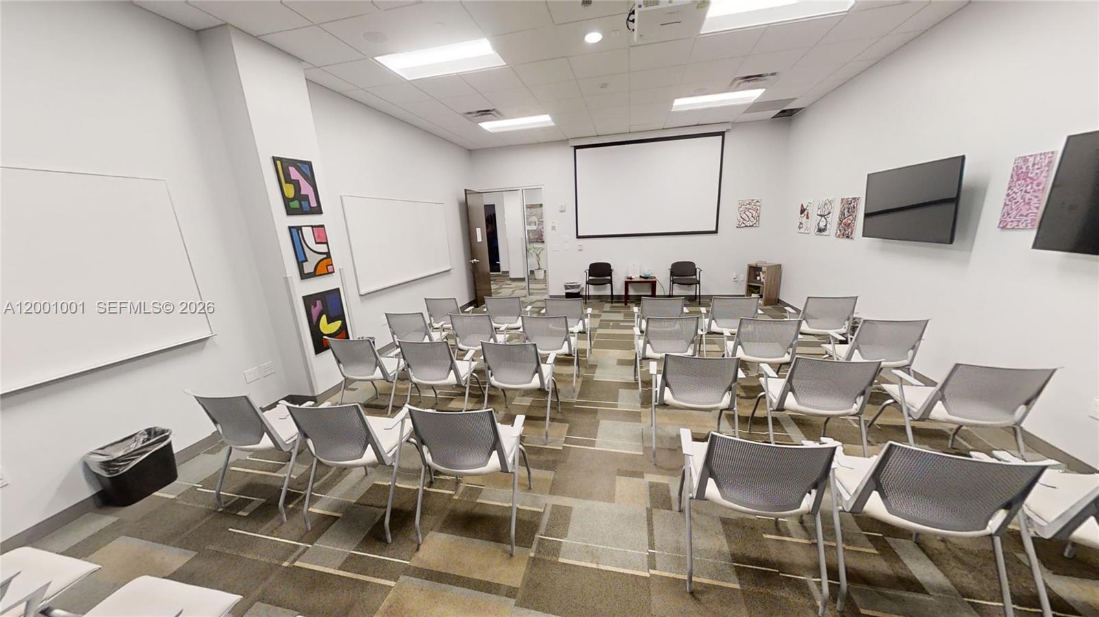 A conference room features rows of chairs, a projector screen, whiteboards, and patterned carpet flooring — 1501 Biscayne Blvd, FL 33132, FL