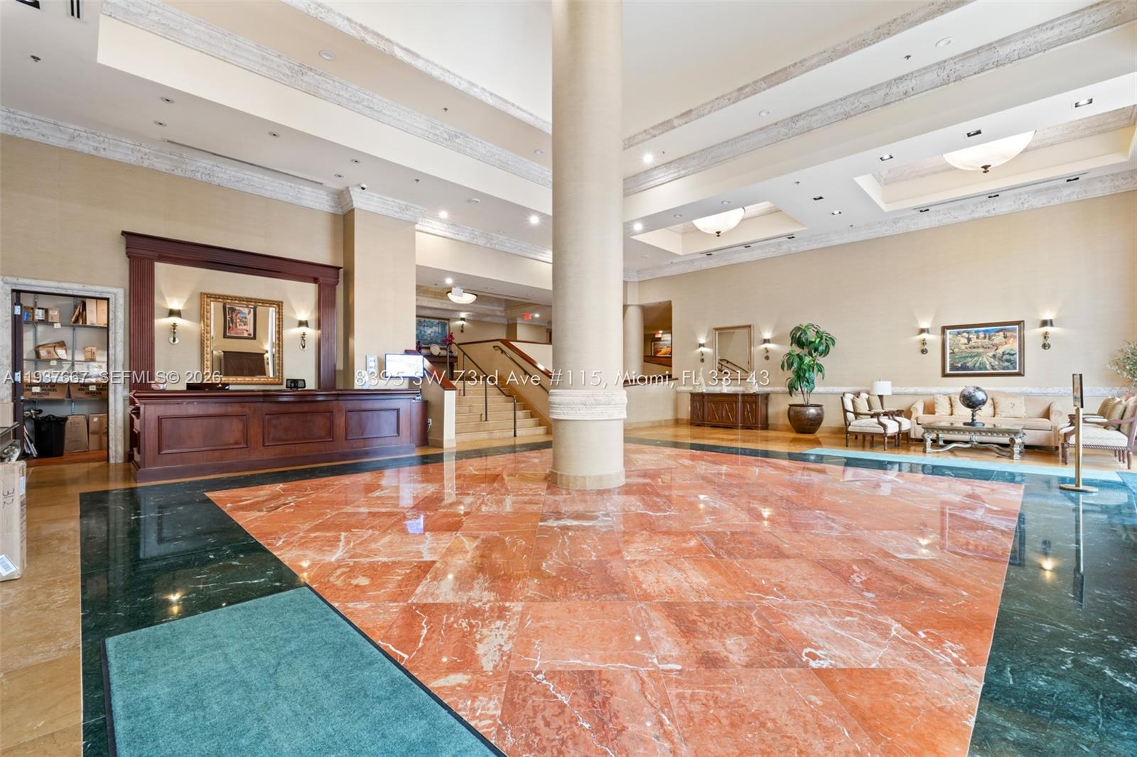 A spacious lobby features a large central column, marble flooring, and a wooden reception desk — 8395 SW 73rd Ave # 115, Miami FL 33143, MIAMI, FL