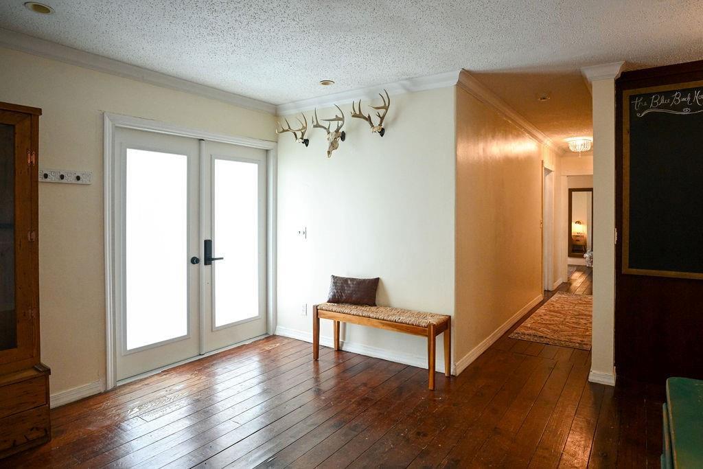 An entryway with hardwood floors, a wooden bench, and deer antlers mounted on the wall — 248 NE 41st Street, Deerfield Beach FL 33064, DEERFIELD BEACH, FL
