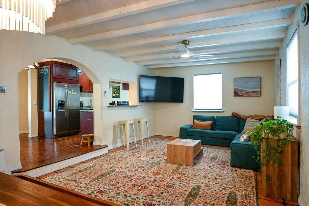 A living room with a teal sectional sofa, a large patterned rug, and exposed beams — 248 NE 41st Street, Deerfield Beach FL 33064, DEERFIELD BEACH, FL