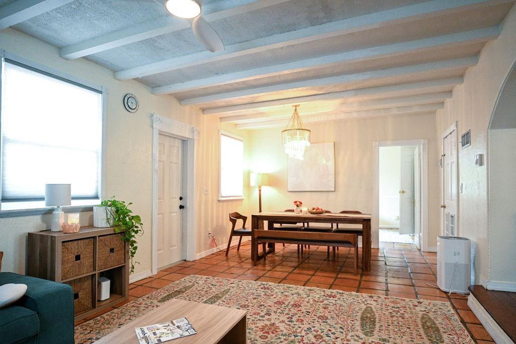 A living and dining area features exposed ceiling beams, terracotta tile floors, and a rug — 248 NE 41st Street, Deerfield Beach FL 33064, DEERFIELD BEACH, FL