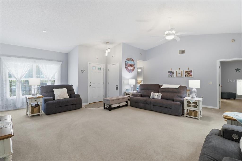 A living room features gray walls, carpeted flooring, a ceiling fan, and gray upholstered furniture — 4155 N LEE STREET, BEVERLY HILLS, FL