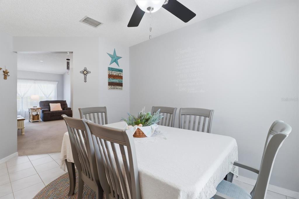 A dining room features a table with six chairs, a ceiling fan, and wall decor — 4155 N LEE STREET, BEVERLY HILLS, FL