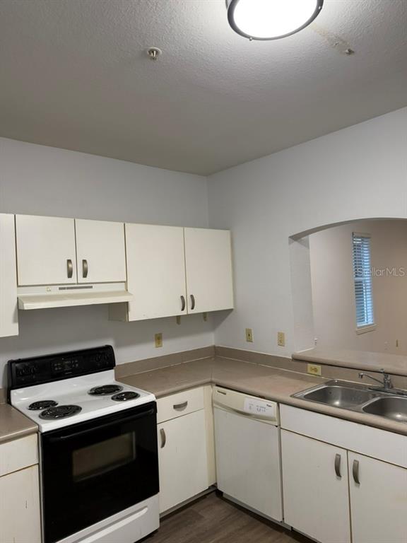 A kitchen features white cabinets, a black electric stove, a dishwasher, and a pass-through window — 1321 ARBOR VISTA  LOOP UNIT 117, LAKE MARY, FL