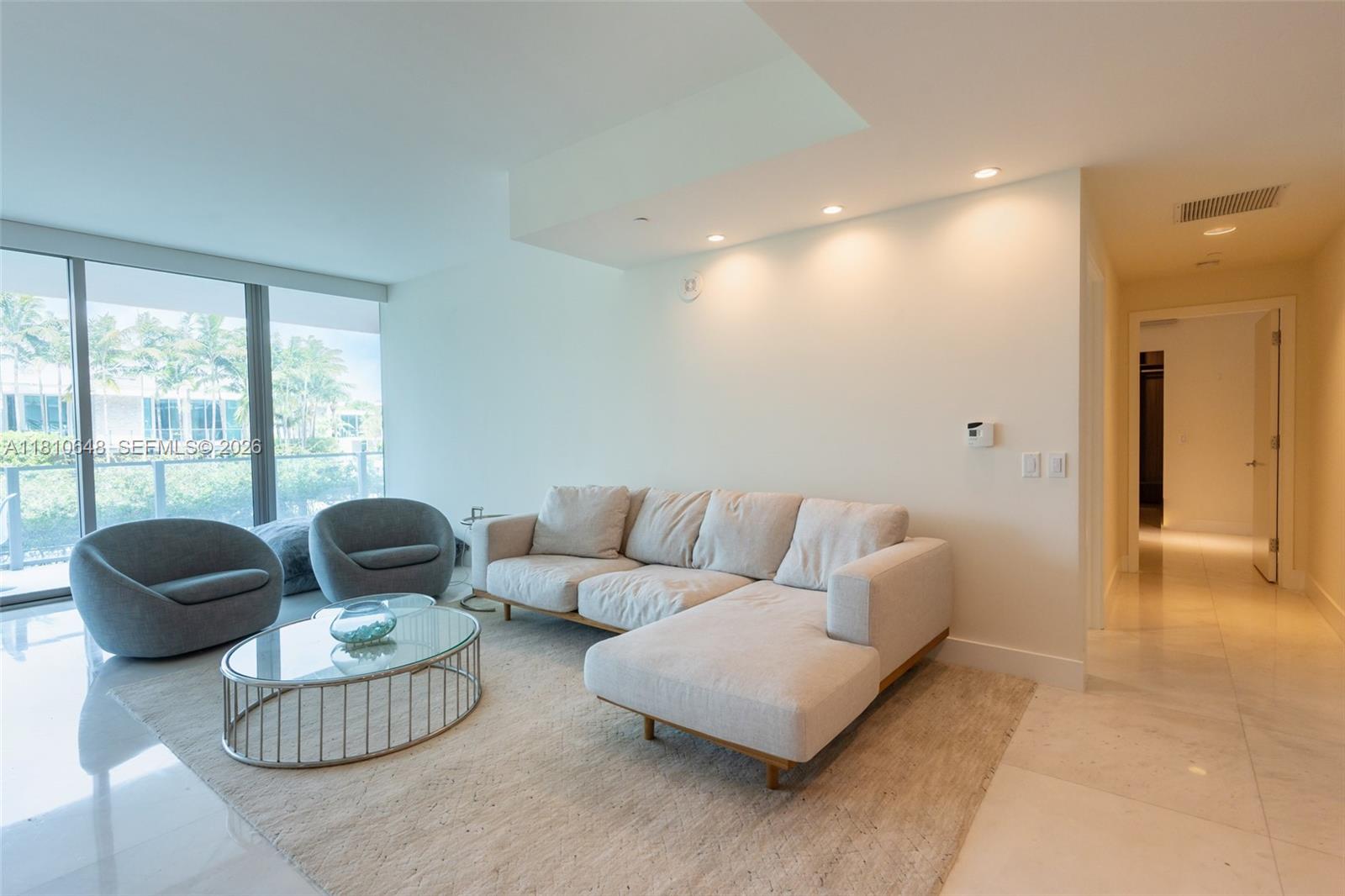 A living room features a beige sectional sofa, two gray armchairs, and a glass coffee table — 360 Ocean Dr # 205S, Key Biscayne FL 33149, KEY BISCAYNE, FL
