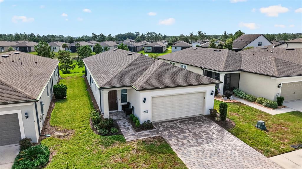 An aerial view of a single-story suburban house with a paved driveway and garage — 6043 SW 93RD CIRCLE, OCALA, FL