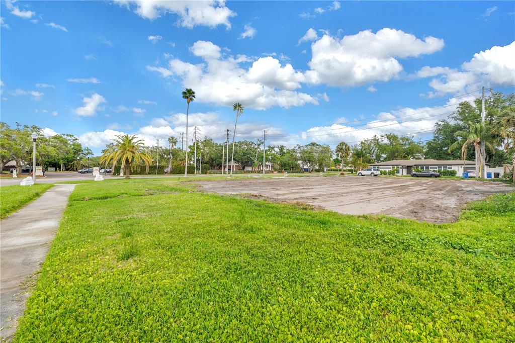 A vacant, grassy lot with a cleared dirt patch sits under a blue sky — 515 SNELL ISLE BOULEVARD NE, ST PETERSBURG, FL