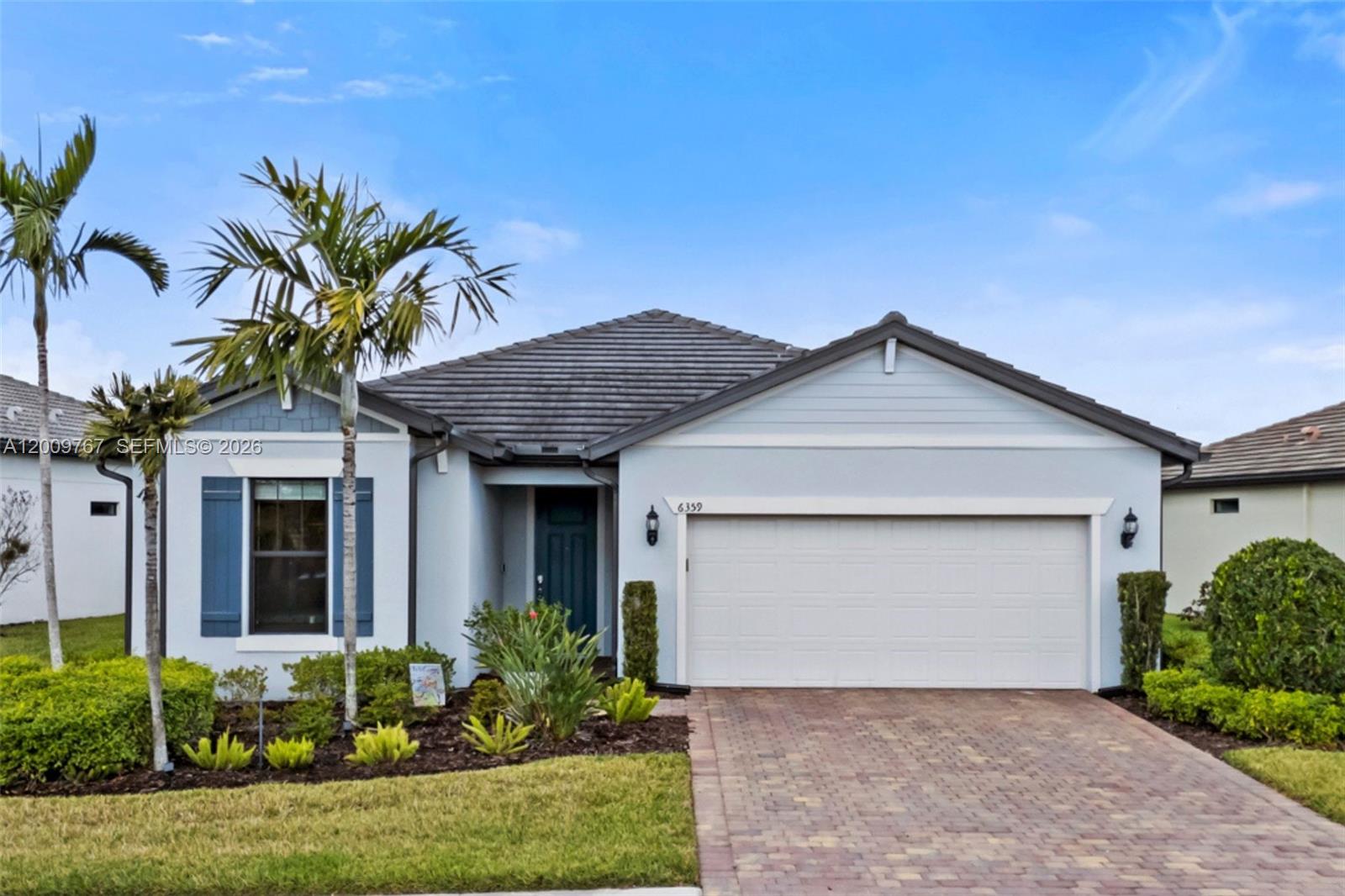 A single-story house with a light blue exterior, a two-car garage, and a paved driveway — 6359 Achievement, Ave Maria FL 34142, AVE MARIA, FL