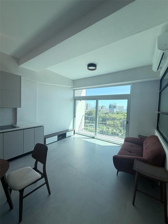 A modern studio apartment features a kitchenette, a sofa, and a balcony with city views — 352 DEL PARQUE, SAN JUAN, PR
