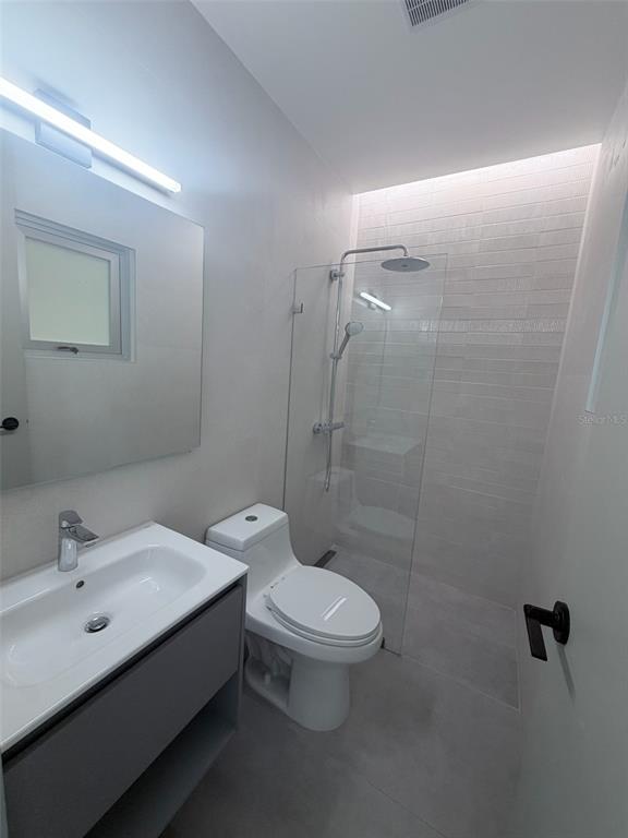 A modern bathroom features a floating vanity, a white toilet, and a glass-enclosed walk-in shower — 352 DEL PARQUE, SAN JUAN, PR