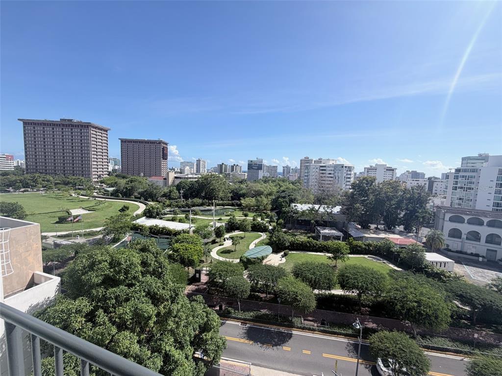 An elevated view shows a city park with green spaces, trees, and surrounding high-rise buildings — 352 DEL PARQUE, SAN JUAN, PR
