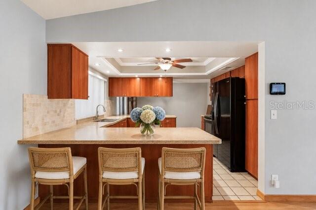 A kitchen features a wooden breakfast bar with three wicker stools and a central island — 8012 PAGODA DRIVE, SPRING HILL, FL