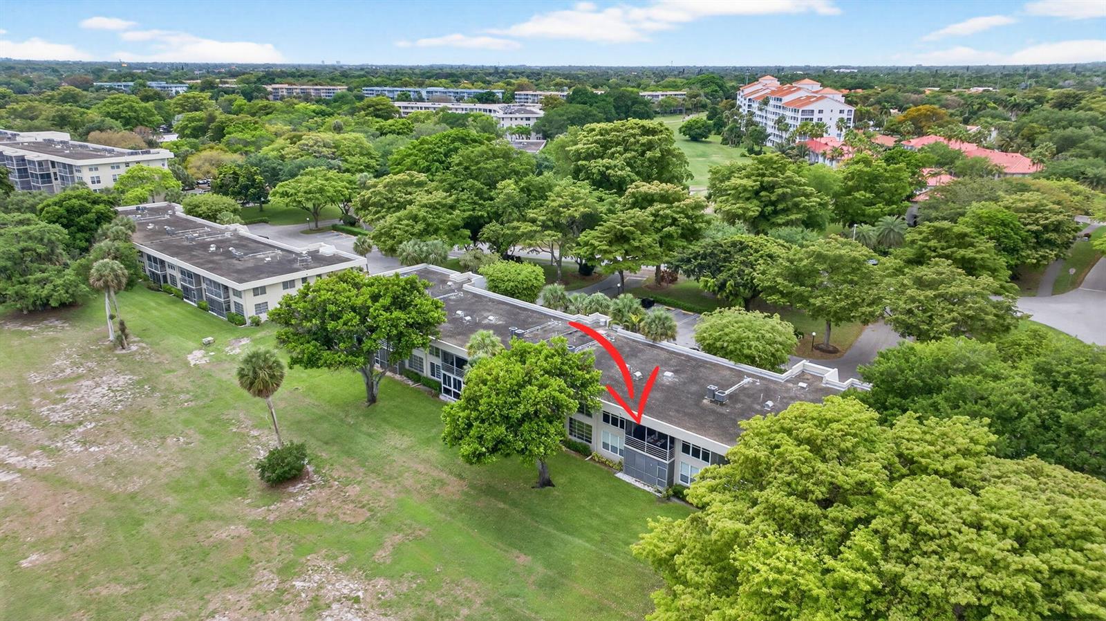 An aerial view shows a multi-story apartment building surrounded by lush green trees and lawns — 800 Cypress Boulevard # 204a, Pompano Beach FL 33069, POMPANO BEACH, FL