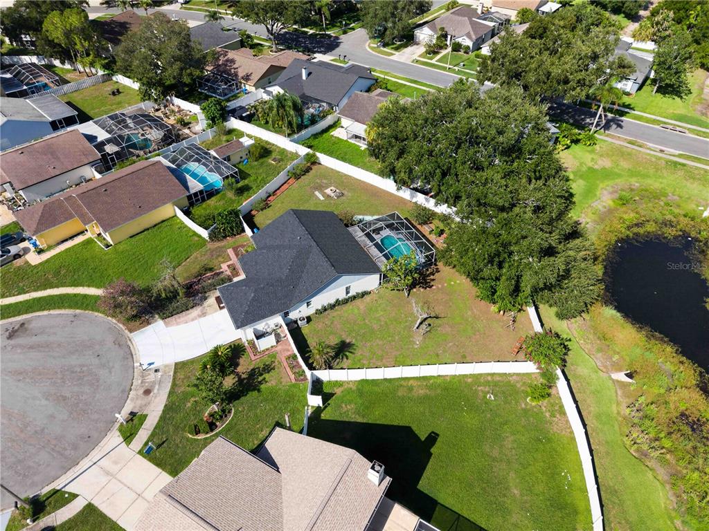 An aerial view shows a residential house with a pool and a large backyard — 1703 LARABIE COURT, BRANDON, FL