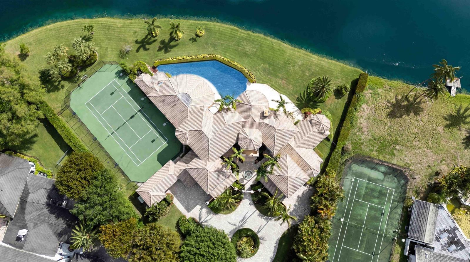 An aerial view shows a large house with a tiled roof, pool, and two tennis courts — 18118 Daybreak Drive, Boca Raton FL 33496, BOCA RATON, FL