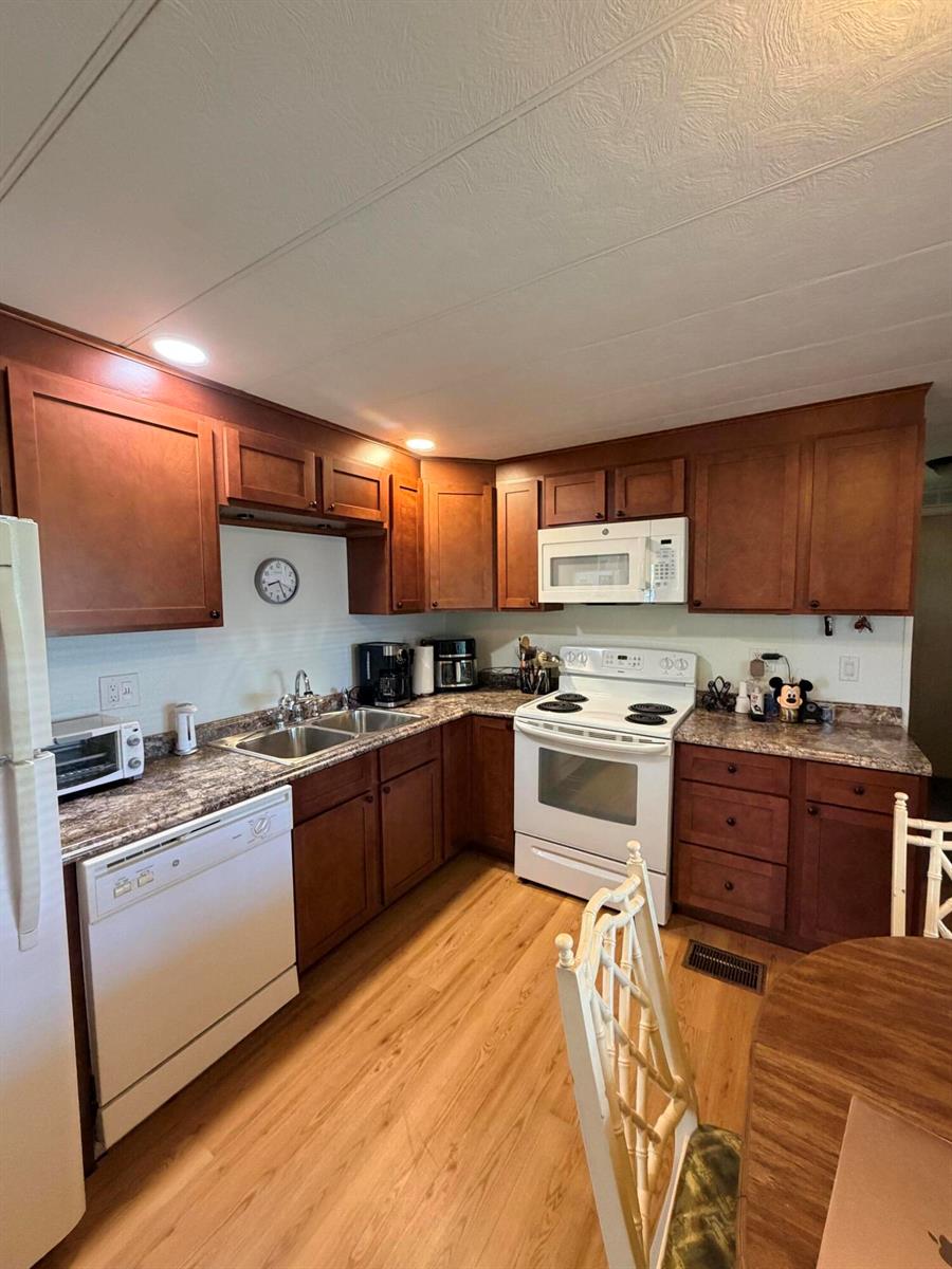 A kitchen with wood cabinets, white appliances, and laminate countertops — 5603 Lagoon Drive, Dania Beach FL 33312, DANIA BEACH, FL