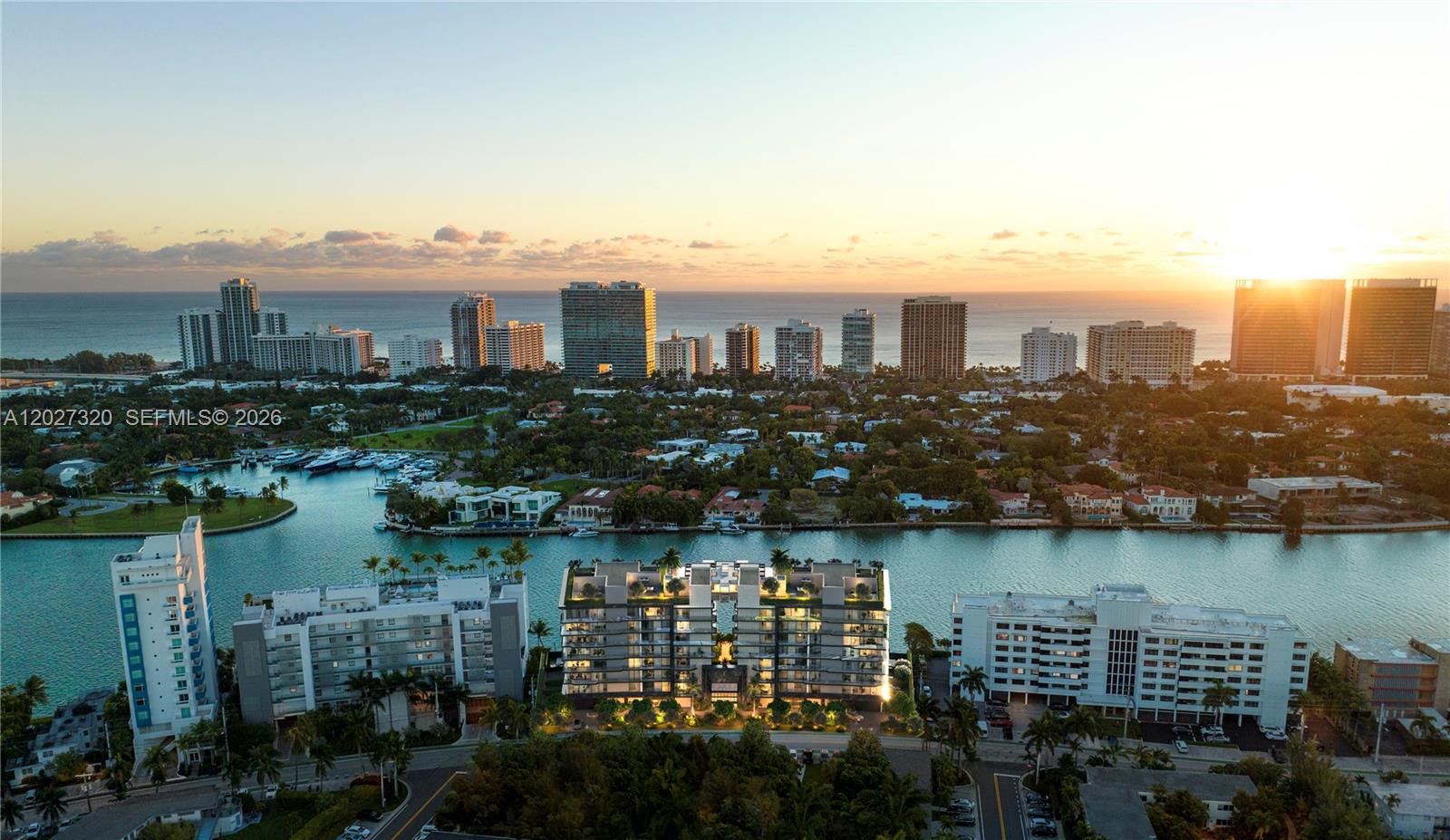 An aerial view shows waterfront residential buildings along a canal with a sunset horizon — 10141 E Bay Harbor Dr. # 301, Bay Harbor Islands FL 33154, BAY HARBOR ISLANDS, FL