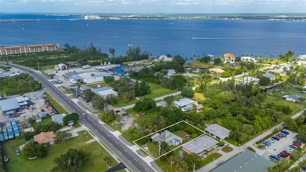 An aerial view shows a residential lot outlined in white near a coastal waterfront — 25158 MARION AVENUE, PUNTA GORDA, FL