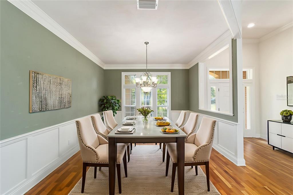 A dining room features a long table, upholstered chairs, green walls, and hardwood floors — 5604 NW 52ND AVENUE, GAINESVILLE, FL
