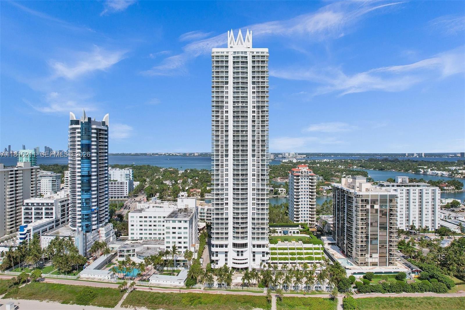 An aerial view shows a tall residential skyscraper surrounded by other buildings near a coastline — 6365 Collins Ave # 2403, Miami Beach FL 33141, MIAMI BEACH, FL