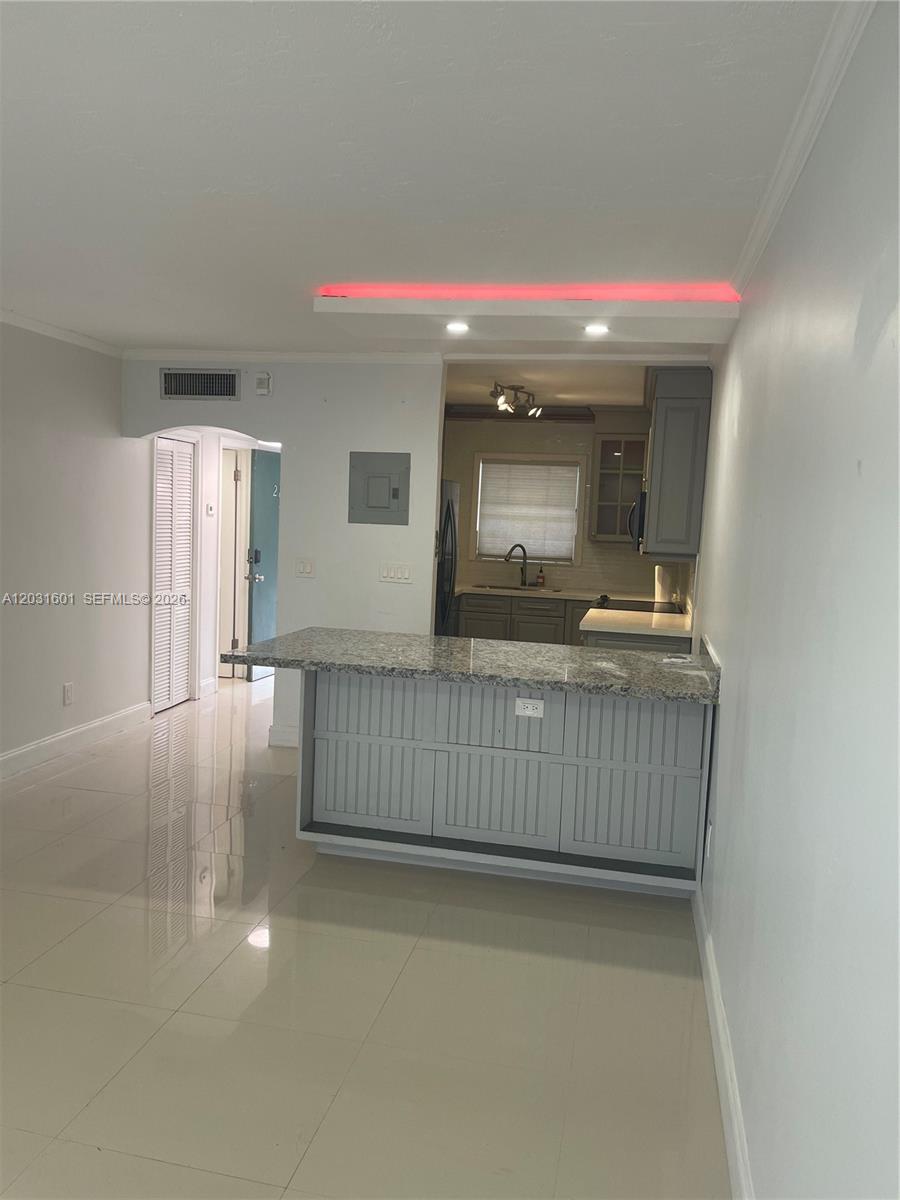 A kitchen with a granite-topped breakfast bar, gray cabinetry, and red accent lighting — 7505 SW 82nd St # 212, Miami FL 33143, MIAMI, FL