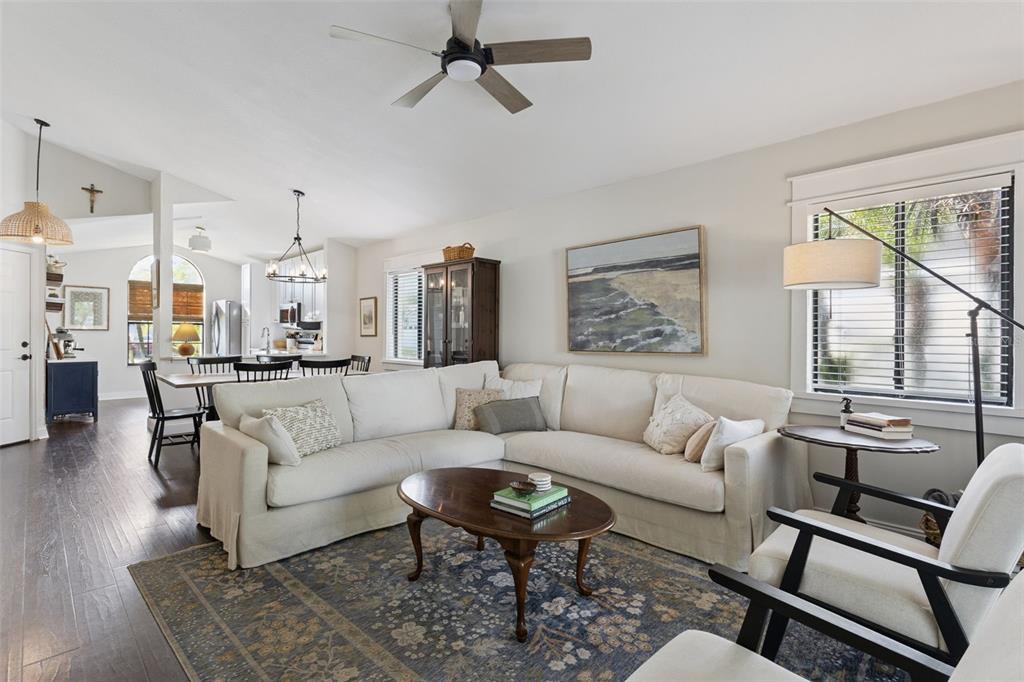 A living room features a white sectional sofa, a wooden coffee table, and dark flooring — 1533 SPRINGTIME LOOP, WINTER PARK, FL