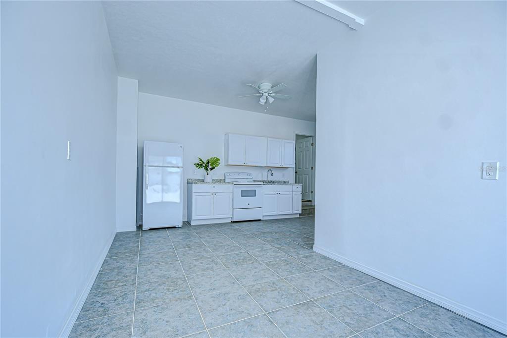 A kitchen with white cabinets, white appliances, and light-colored tile flooring — 150 E MADEIRA AVENUE UNIT 3, MADEIRA BEACH, FL