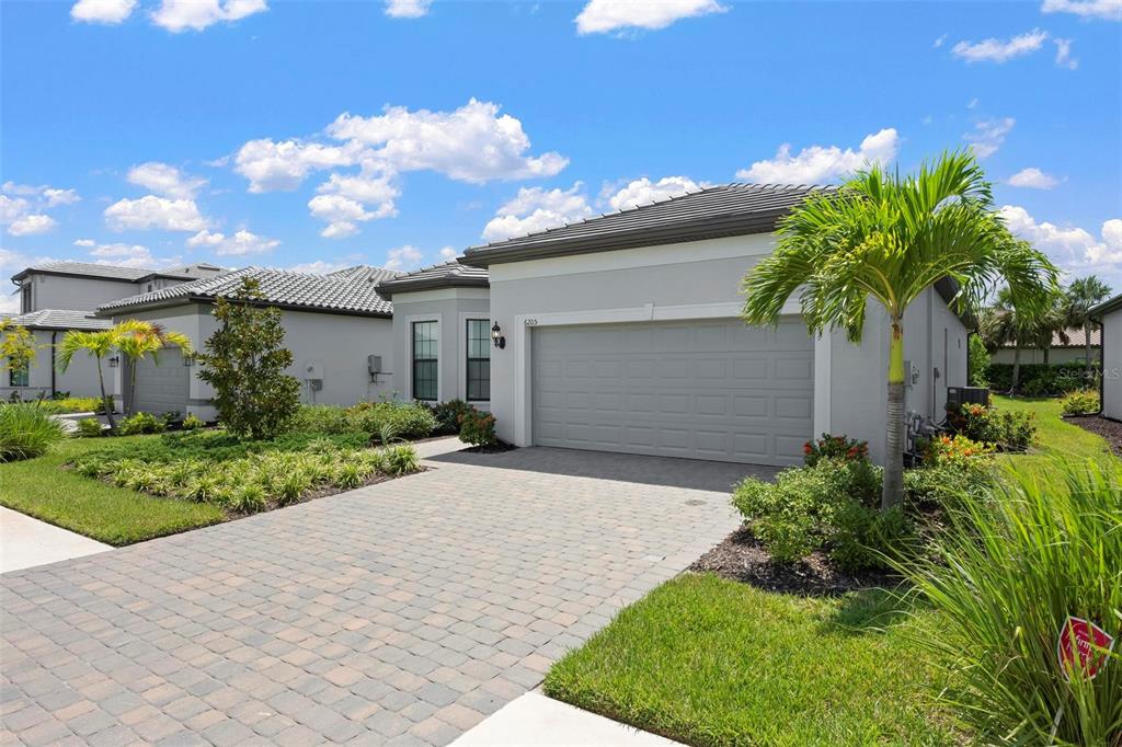 A single-story suburban house with a gray exterior, a two-car garage, and a paved driveway — 6205 GRANDE TALON LANE, NOKOMIS, FL