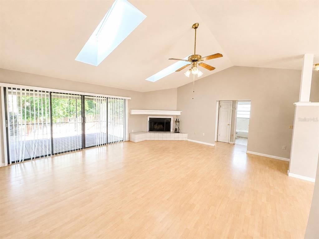 A spacious living room features light wood flooring, a corner fireplace, and two skylights — 700 SOUTH VENICE AVENUE, VENICE, FL