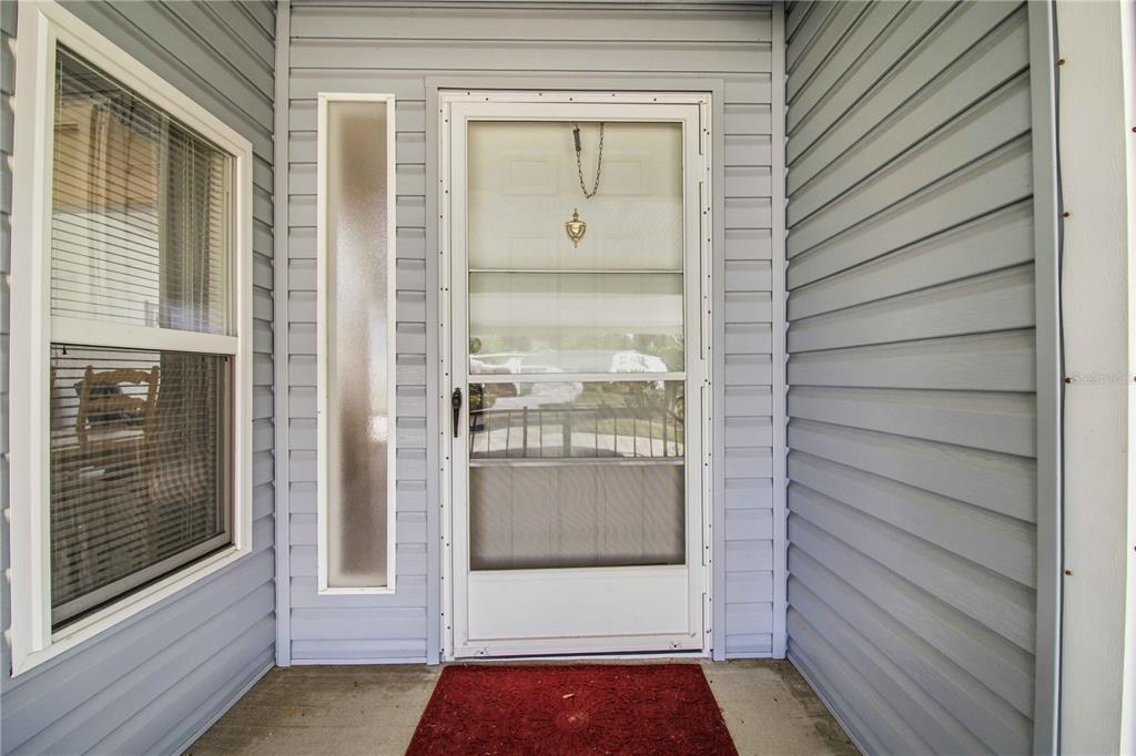 A front entryway features a white storm door, a side window, and light blue siding — 8476 IMPERIAL CIRCLE, PALMETTO, FL