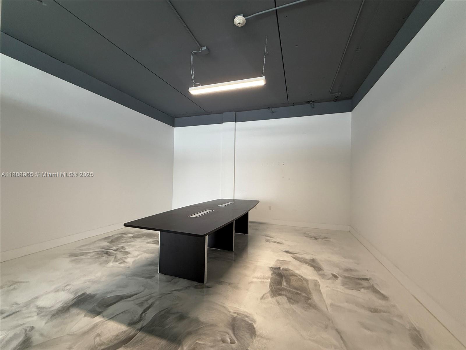 A conference room features a dark table, white walls, and a marbled gray floor — 42 NW 27th Ave # 302, Miami FL 33125, MIAMI, FL