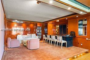 A room features wood-paneled walls, a bar with stools, and a small seating area — 11111 Biscayne Blvd # 227, North Miami Beach FL 33181, NORTH MIAMI BEACH, FL