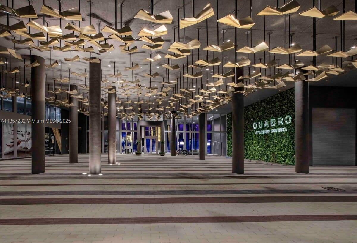 A modern building entrance features a ceiling installation of gold-colored geometric panels and cylindrical columns — 3900 Biscayne Blvd # 1009, Miami FL 33137, MIAMI, FL