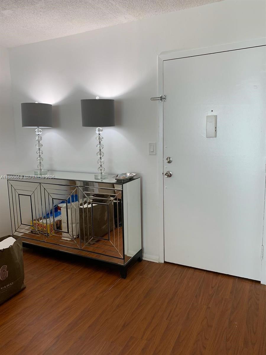 A mirrored console table with two lamps stands next to a white entry door — 851 Three Islands Blvd # 308, Hallandale Beach FL 33009, HALLANDALE BEACH, FL