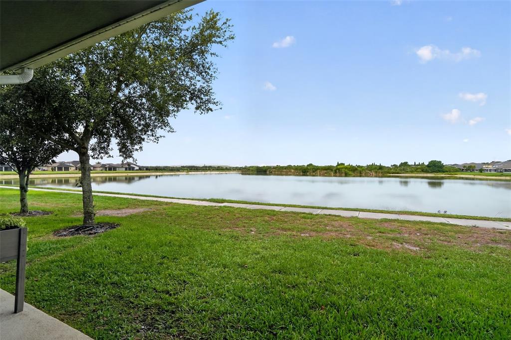 A view of a grassy lawn and a pond from a covered patio — 4749 SOMERSET HILL LANE, RIVERVIEW, FL