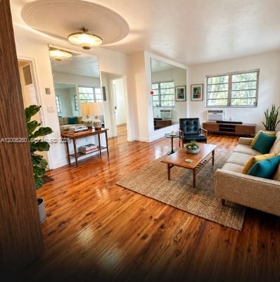 A living room features hardwood floors, a beige sofa, a coffee table, and large mirrors — 4740 Pine Tree Dr # 20, Miami Beach FL 33140, MIAMI BEACH, FL