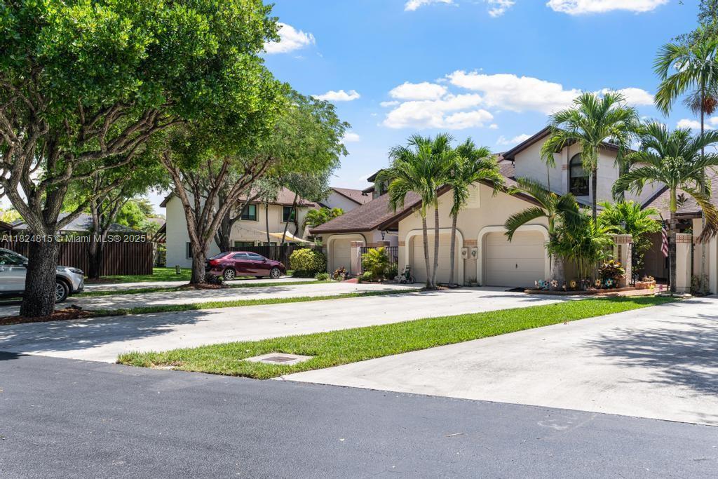 A two-story residential building with a multi-car garage and a paved driveway — 10091 SW 137th Pl, Miami FL 33186, MIAMI, FL