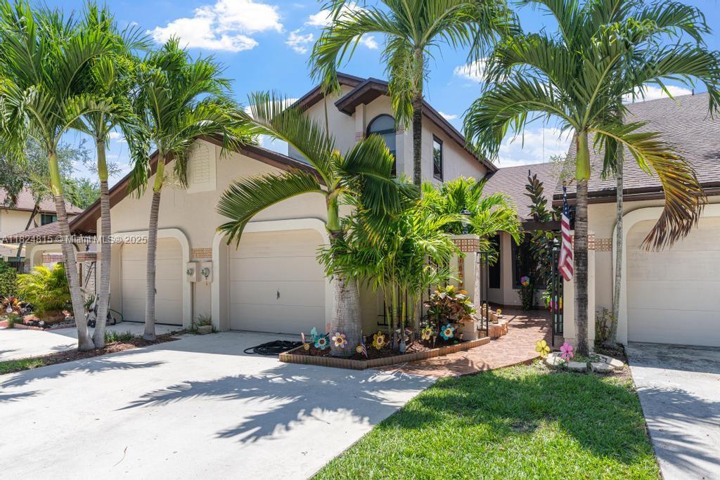 The exterior of a two-story house features a multi-car garage, palm trees, and a walkway — 10091 SW 137th Pl, Miami FL 33186, MIAMI, FL