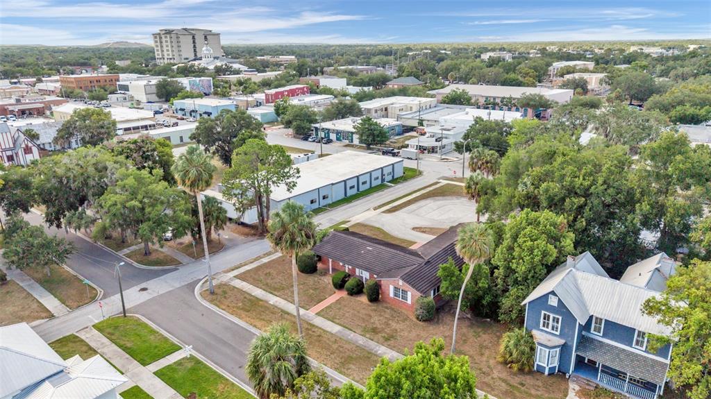 An aerial view shows a residential street with a blue house and a brick house — 510 E PARKER STREET, BARTOW, FL