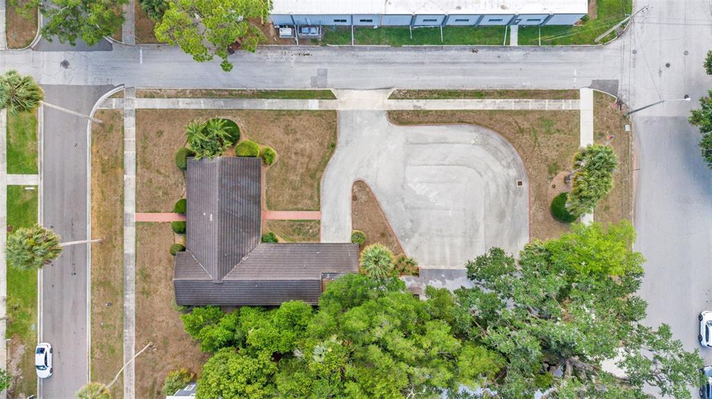 An aerial view shows a house with a dark roof, a large paved driveway, and trees — 510 E PARKER STREET, BARTOW, FL