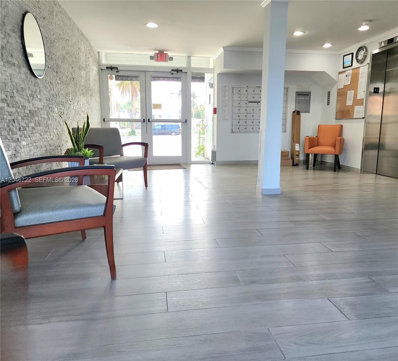 A lobby features gray wood-look tile flooring, a stone accent wall, and several seating areas — 211 S Ocean Dr # 501, Hollywood FL 33019, HOLLYWOOD, FL