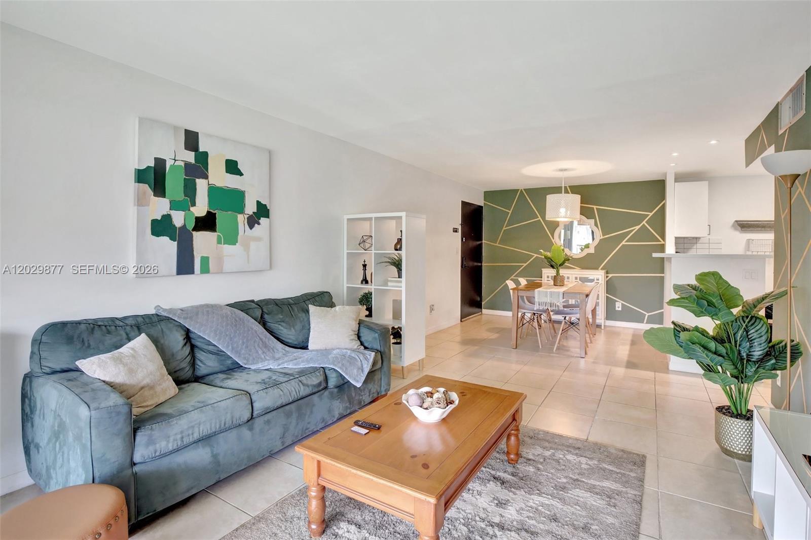A living and dining room features a green accent wall with gold geometric lines — 5821 Washington St # 30, Hollywood FL 33023, HOLLYWOOD, FL