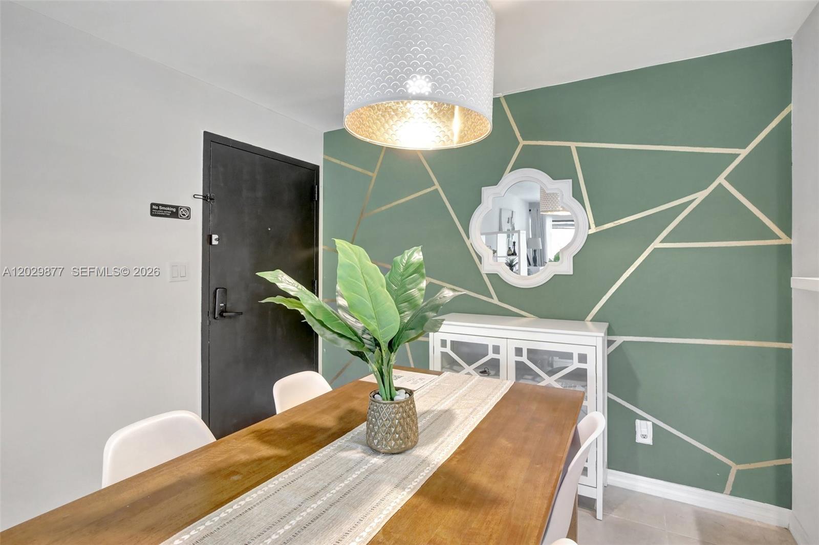 A dining room features a green accent wall with gold geometric lines and a chandelier — 5821 Washington St # 30, Hollywood FL 33023, HOLLYWOOD, FL