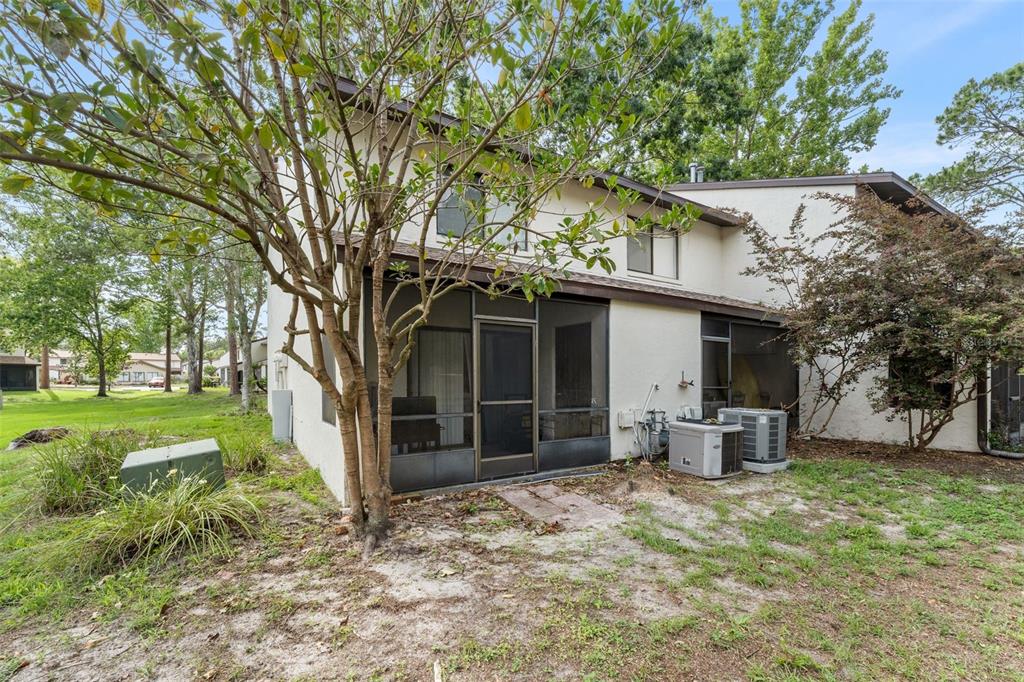 The exterior of a two-story townhouse features a screened-in patio and two air conditioning units — 2635 SW 35TH PLACE UNIT 307, GAINESVILLE, FL