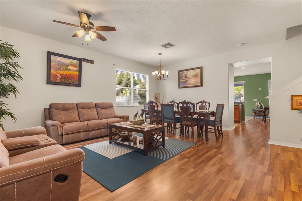 A living and dining room area with brown furniture, wood flooring, and a ceiling fan — 402 VINE CLIFF STREET, RUSKIN, FL