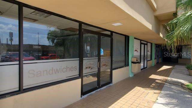 The exterior of a commercial storefront features glass doors and windows with signage for a restaurant — Forest Hills PR-167 INT. CLL-15, BAYAMON, PR