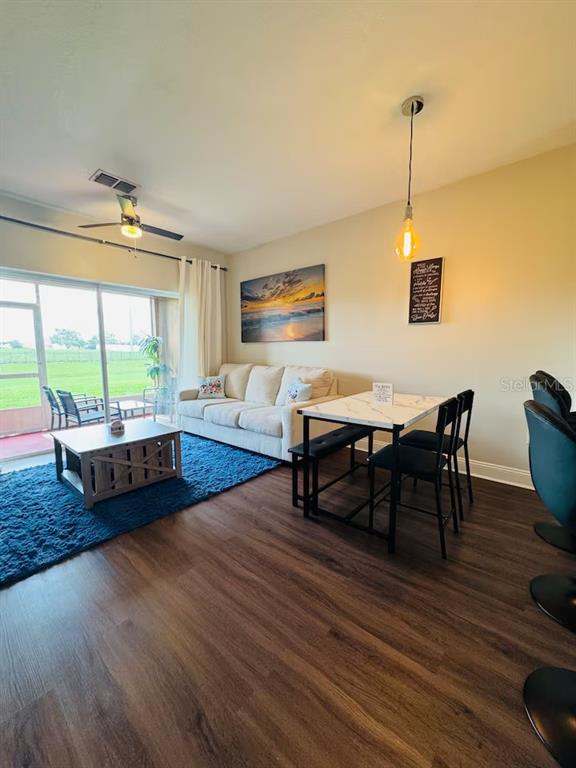 A living room features a beige sofa, a blue rug, and a dining table — 774 CHELSEA DRIVE, DAVENPORT, FL
