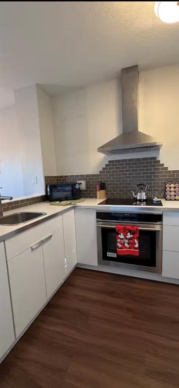 A kitchen features white cabinets, stainless steel appliances, and a gray tiled backsplash — 774 CHELSEA DRIVE, DAVENPORT, FL